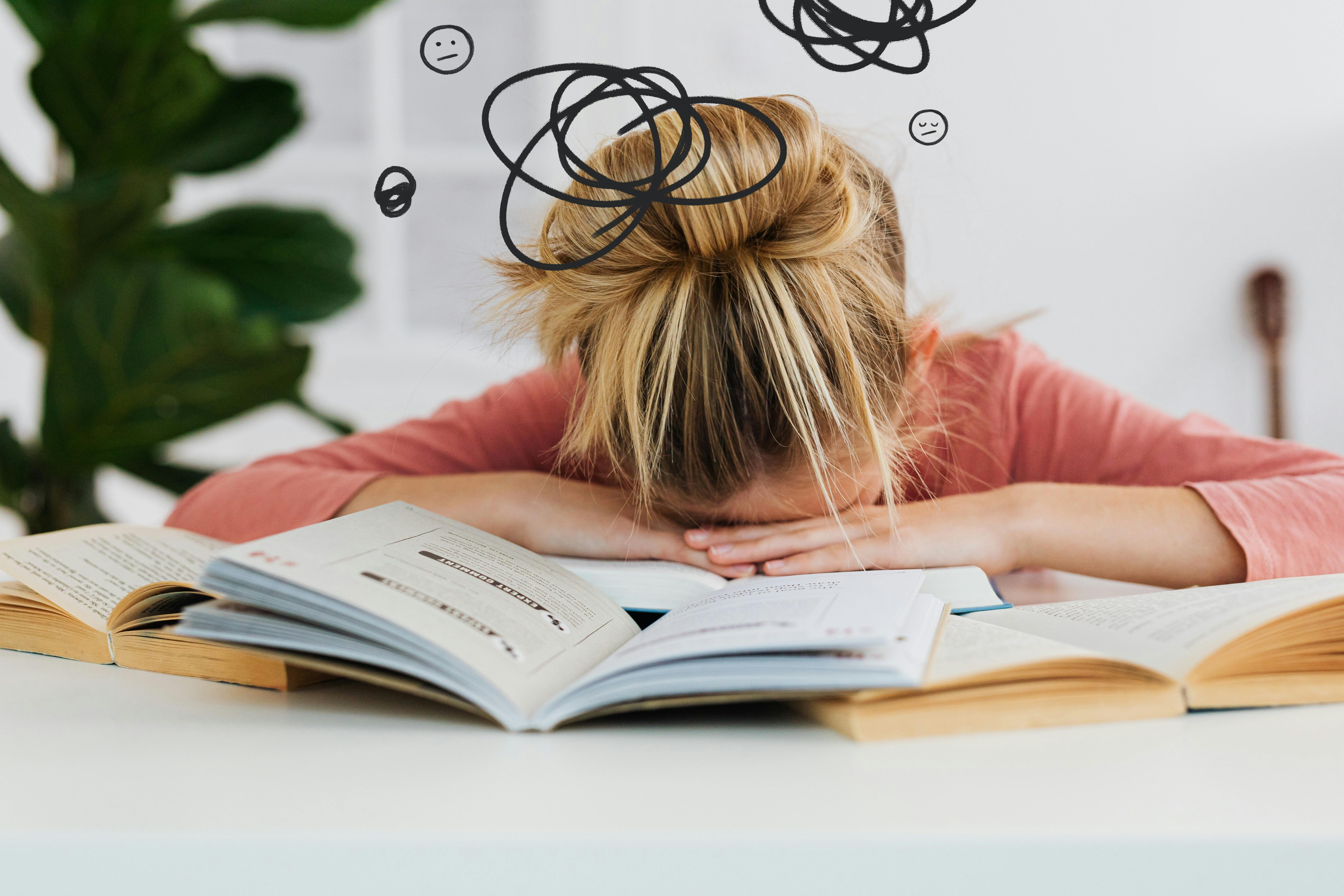 A woman with her head in hands on a desk